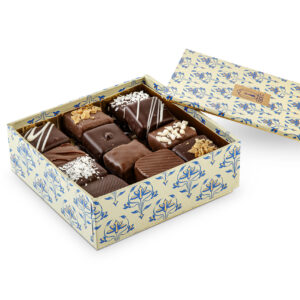 Composition garnie de chocolats de fabrication artisanale maison. Caramel, praliné, chocolat noir, chocolat au lait, éclat de cacahuète...